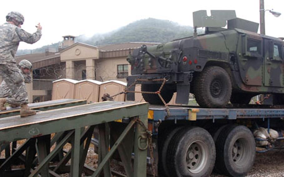 Soldiers from 2nd Battalion, 9th Infantry Regiment help offload one of 30 up-armored Humvees that arrived at Camp Hovey on Thursday.