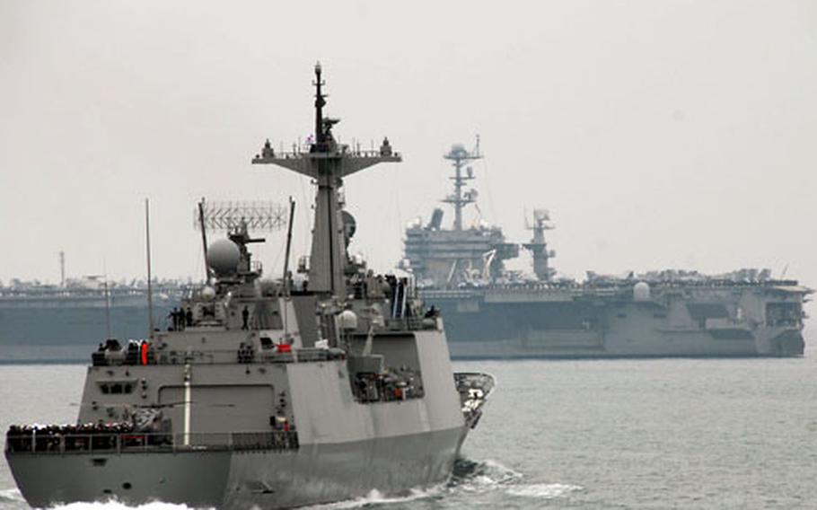 The ROKS Kangkamchan steams toward the USS George Washington on Tuesday during South Korea’s International Fleet Review "pass and review." The George Washington arrived in the Pacific last month after undergoing repairs.