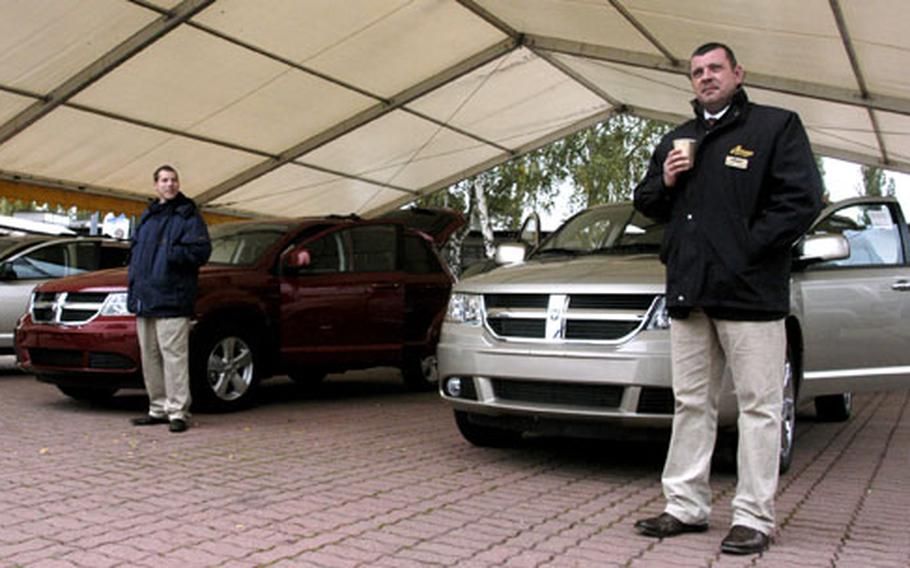 Car salesmen at Exchange New Car Sales at the Vogelweh shopping center in the Kaiserslautern military community wait for customers on a chilly October morning. Fewer customers purchased cars through the Exchange New Car Sales program this September than last, but sales are still doing better this year than last.