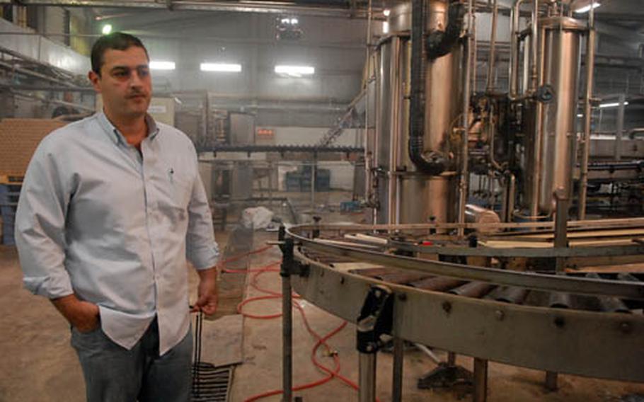 Zaid al-Khafaji inspects the floor of the Dijla Soft Drink Co. factory Tuesday in Baghdad’s Abu T’shir district. Al-Khafaji, who runs the company, returned to Iraq in April and ramped up his factory’s production after a 2 ½ year absence. American officials are trying to regrow Iraq’s economy by attracting businessmen like al-Khafaji back home.