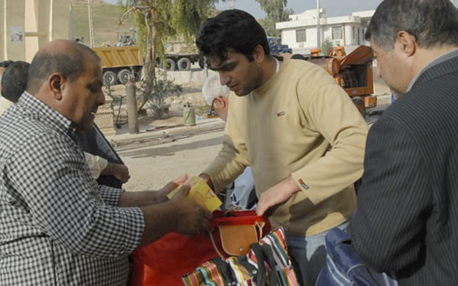 A border agent, left, hand-searches luggage at a crossing near the town of Konnikin. The Iraqi Border Patrol is undermanned, often resulting in long lines at crossings between Iran and Iraq.