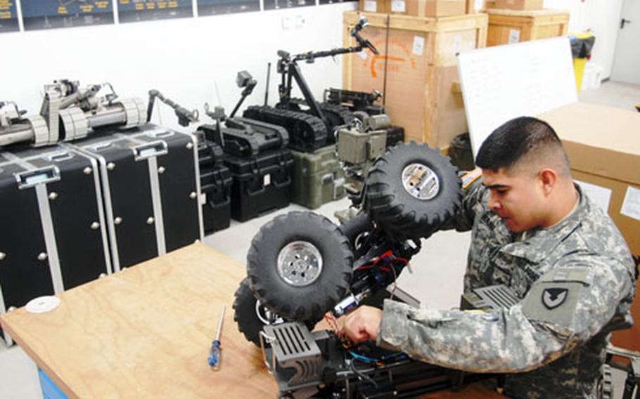 Sgt. Miguel Haro works on a robot at Hohenfels, Germany, on Monday. Most damage to the robots occurs because of operator error, Haro said.
