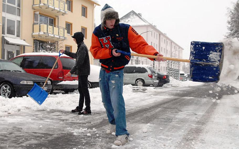 Alex Lewis, left, and Ethan Montang, both juniors at Baumholder, Germany, high school, clear snow from a parking lot in Smith Barracks housing area. A late autumn storm Wednesday morning dumped a couple of inches of snow onto western Germany, forcing Baumholder schools to close and delaying buses in the Kaiserslautern area.