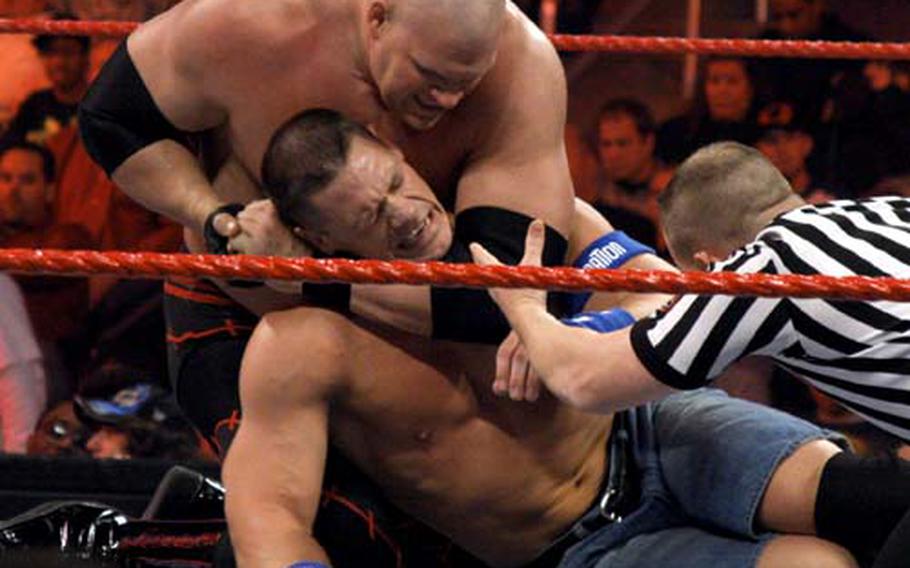 John Cena, center, tries to free himself from Kane&#39;s headlock. Cena has traveled to Iraq five times with the WWE Tribute to the Troops tour.