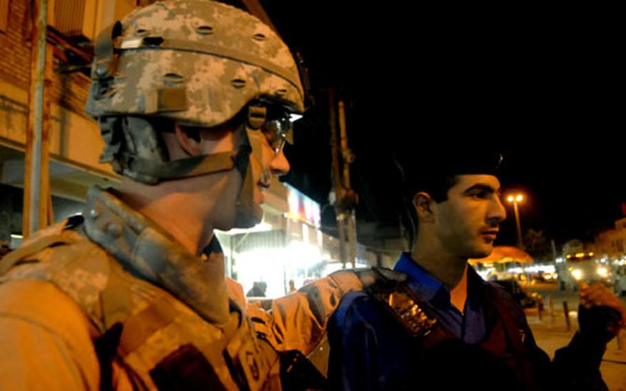 Air Force Master Sgt. Tom Daniels gives some pointers to an Iraqi Police officer during a joint patrol in south Baghdad.