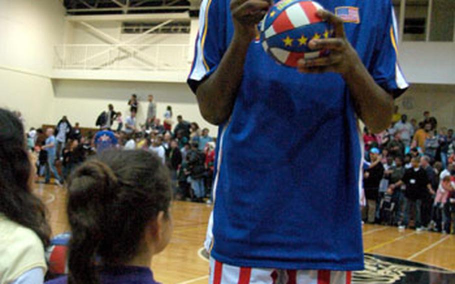 The 7-foot-3-inch Shagari “Skyscraper” Alleyne signs autographs for fans Friday night in the Samurai Fitness Center at Yokota Air Base, Japan.
