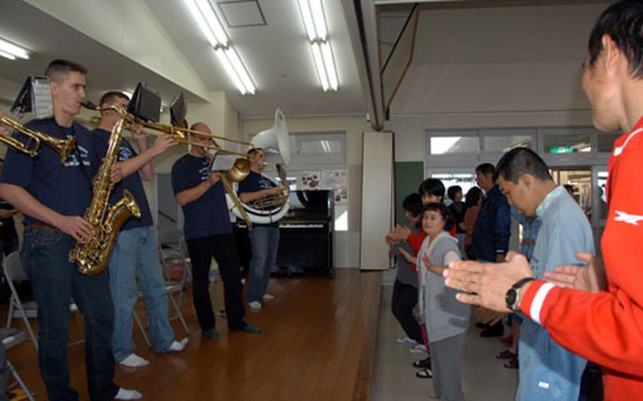 Twelve members of the the U.S. Army Japan Band perform as residents from the Takashihoen facility dance. The performance was the band’s second at the facility for developmentally disabled adults.