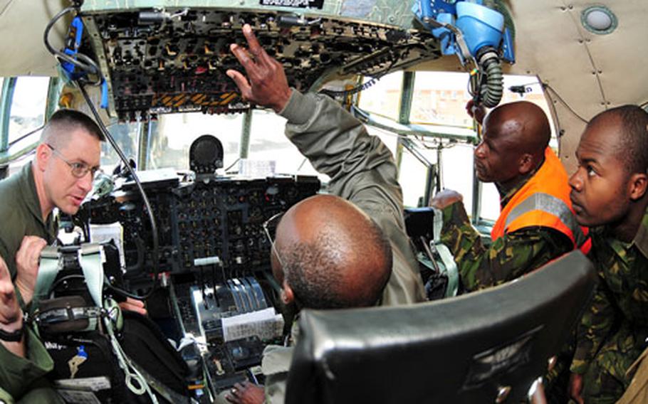 Master Sgt. James Pentergast, left, 37th Airlift Squadron C-130 flight engineer, shows the cockpit of one of the U.S. C-130s to members of the Botswana Defense Force.