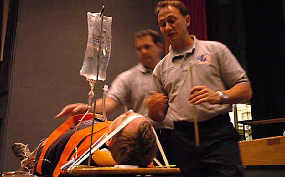 “Street Smart” presenters Vince Easevoli, front, and Joseph McCluan demonstrate with the help of volunteer Steven Marksberry the injuries that can occur in drunken-driving accidents on Tuesday at Yokosuka Naval Base, Japan. Street Smart demonstrates the consequences of poor choices such as drunken driving, drug abuse and not wearing seat belts.