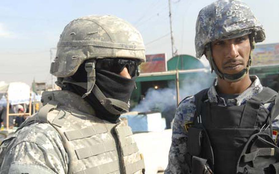 An Iraqi interpreter, left, translates a conversation between an Iraqi National Police officer and U.S. soldiers in Baghdad.