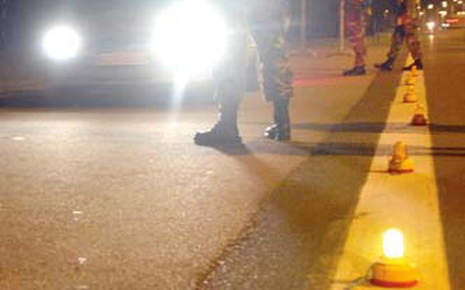 Werner Pfirrmann, a German police officer from the 435th Security Forces Squadron, stops a vehicle at a DUI checkpoint just outside Ramstein Air Base’s west gate in August 2007. The military is stepping up patrols, sobriety checkpoints and working with local police this holiday season to try to cut down on drunken driving.