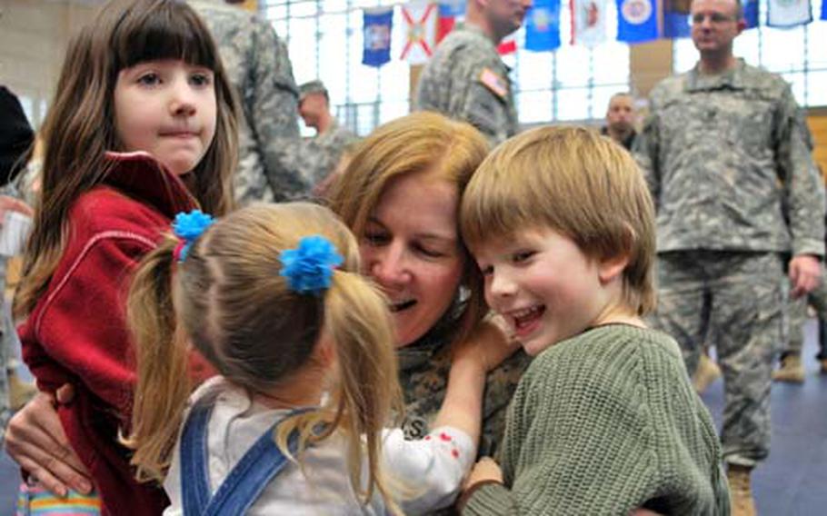 Maj. Peggy Kageleiry is swarmed by her children, Olivia, 6; Charlie, 4; and Mia, 3, upon her return.