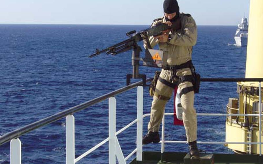 A member of the Dutch special forces stands guard near the bridge of Dutch cargo ship MV Jumbo Javelin as it passes near the Gulf of Aden on Monday, Dec. 8, 2008. The Dutch warship De Ruyter, seen in the background, is escorting the cargo ship through the Gulf of Aden, which has become the world&#39;s top piracy hotspot this year.
