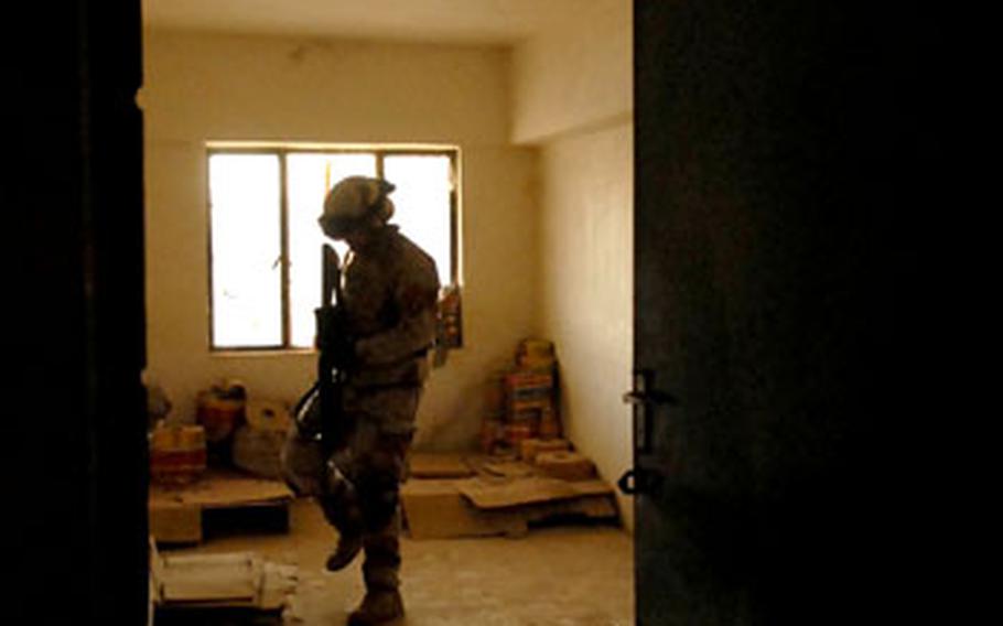 Iraqi army Cpl. Abbas Kadim searches a room in a flour storage building Saturday in Baghdad’s Sadr City district. The Iraqi army will participate in every U.S. operation starting Jan. 1 in preparation for the day when they will eventually work without American help.