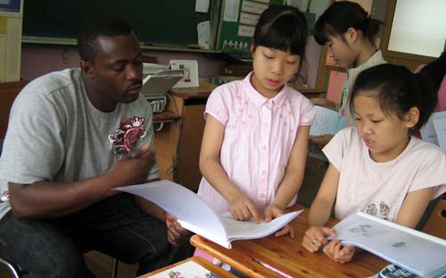 U.S. soldiers from Camp Carroll, South Korea, work with children at Gwanho Elementary School on their English earlier this year.