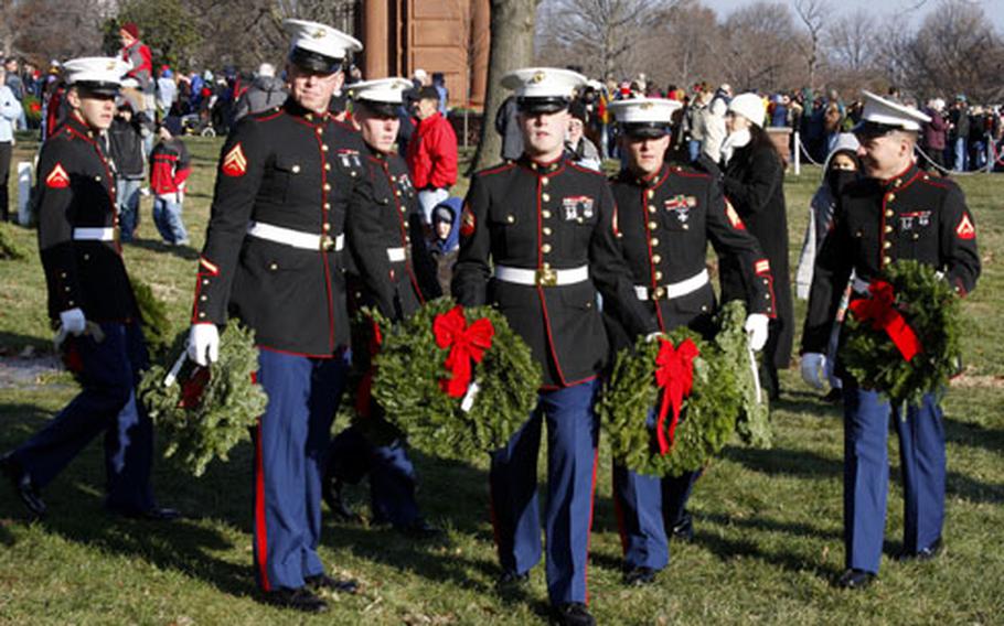 Marines look for an area to place their wreaths during Saturday’s Wreaths Across America event at Arlington National Cemetery.