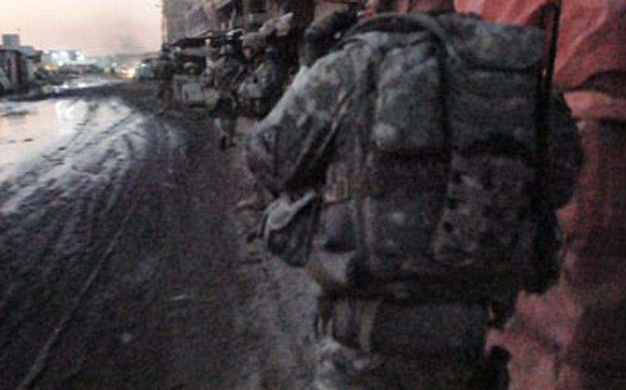 Staff Sgt. Christopher Dyer, a platoon sergeant with Company A, 1st Battalion, 6th Infantry Regiment, walks through the Jamilla market during a patrol Saturday night. The market was the scene of heavy fighting until soldiers built a wall that limited the movement of Mahdi Army members.
