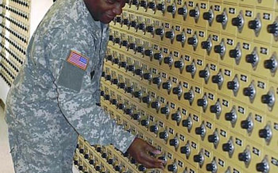 Army Master Sgt. Johnnie Davis with the 7th Civil Support Command checks his mail Monday at Daenner Kaserne in Kaiserslautern, Germany. A mistake at a U.S. Postal Service center in New York City is causing delivery delays in mail that was sent from the States to Europe in November.