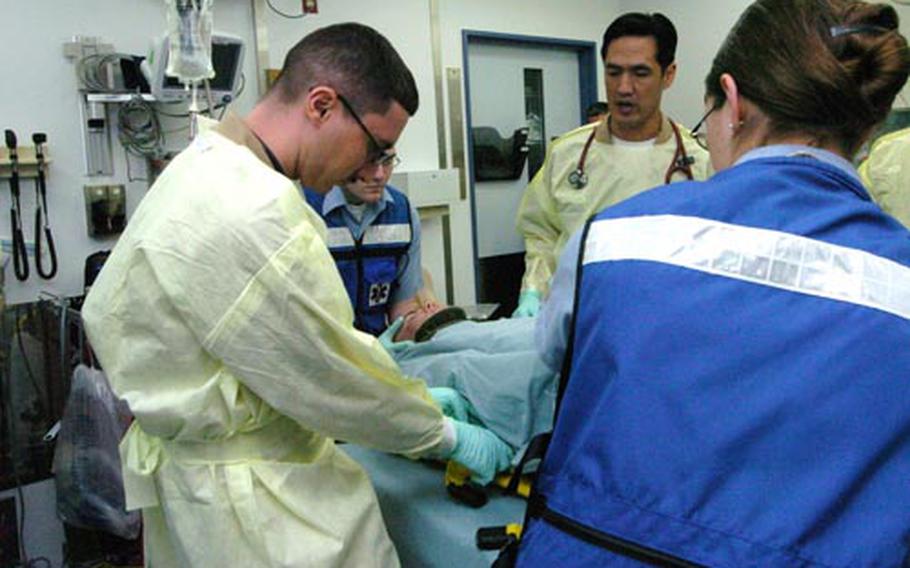 Yokosuka Naval Hospital workers tend to an injured sailor during Tuesday&#39;s joint response drill at Yokosuka Naval Base. As part of the drill, the sailor simulated a broken leg and was exposed to small levels of radiation while aboard the nuclear-powered aircraft carrier USS George Washington. The purpose of the drill was to exercise communication and response capabilities between the U.S. Navy and the city of Yokosuka. During the drill, a sailor broke his leg and was exposed to small levels of radiation while aboard the nuclear-powered aircraft carrier. The purpose of the drill was to exercise communication and response capabilities between the U.S. Navy and the city of Yokosuka.