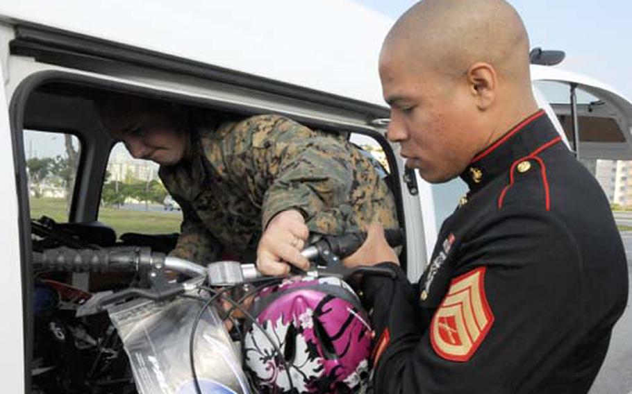 Staff Sgt. Marcus Barhona, right, a Toys for Tots coordinator, helps Staff Sgt. Jeremy Hinkhouse, a volunteer, load a bicycle into the Toys for Tots van Thursday outside the Navy Federal Credit Union on Camp Hansen. The credit union, with the help of the Marine Thrift Shop, donated $1,000 worth of toys. Credit union employees donated an additional $800 worth of toys.