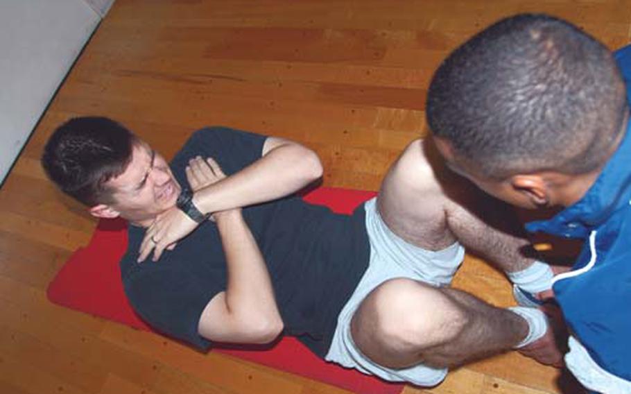 Staff Sgt. Warren Wilson grimaces through sit-ups during his Air Force physical fitness test at Misawa Air Base, Japan in 2007.