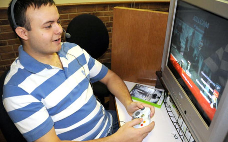 Airman 1st Class Michael Parker, with 18th Comptroller Squadron, smiles as he makes a "kill" in "Call of Duty: World at War" atthe Kadena Air Base, Okinawa, United Service Organizations building Saturday morning. He and a friend were playing a no-win, no lose, free-for-all coordinated by Pro Vs. GI Joe with troops in Kuwait and Wake Forest University football players in the States.