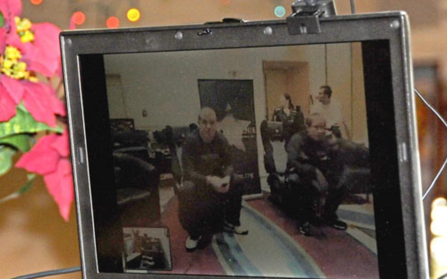 A webcam link-up allows soldiers at Camp Virginia, Kuwait, and airmen at the Kadena Air Base, Okinawa, USO building to see each other Saturday as they play "Call of Duty: World at War" together online.