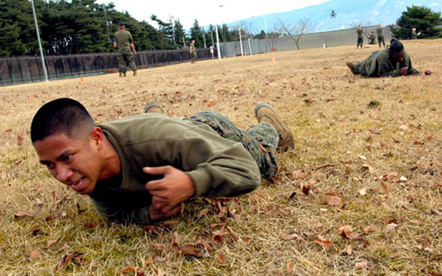 Marines low crawl as part of the Combat Fitness Test at Camp Fuji.