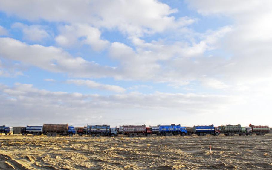 A line of Afghan-driven "jingle trucks" waits to leave a U.S. base in southeastern Afghanistan. The military depends on local transport to move fuel, but officers say the drivers are often inexperienced and understandably jittery on the dangerous rides.