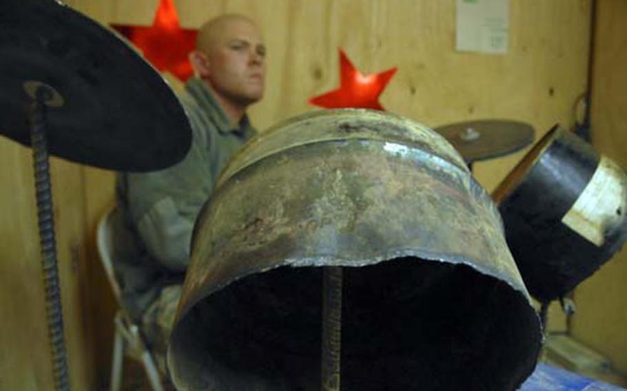 Spc. David Brasket, a medic attached to Company C, 1st Battalion, 506th Infantry Regiment, plays a hand-crafted drum set made from scrap metal, old oil drums and a garbage can as part of Christmas festivities at Combat Outpost Kushmand in southeastern Afghanistan.