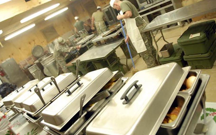 Cooks at Combat Outpost Kushmand in southeastern Afghanistan put the finishing touches on a Christmas meal.