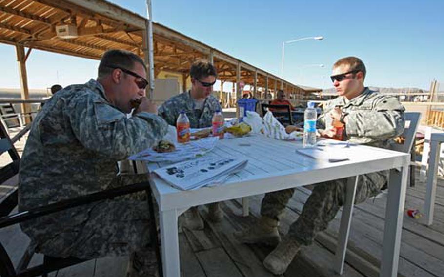 Sgt. Mike Dean, 28, of Hamilton, Ohio, Sgt. Wade Pommer, 27, of Bowler, Wis., and Spc. Jordan Carpenter, 21, of Bartlett, Tenn., eat Subway sandwiches for a late Christmas Day lunch on the boardwalk at Kandahar Airfield, Afghanistan. The three soldiers said they would probably eat traditional Christmas dinner at the mess hall later in the evening.