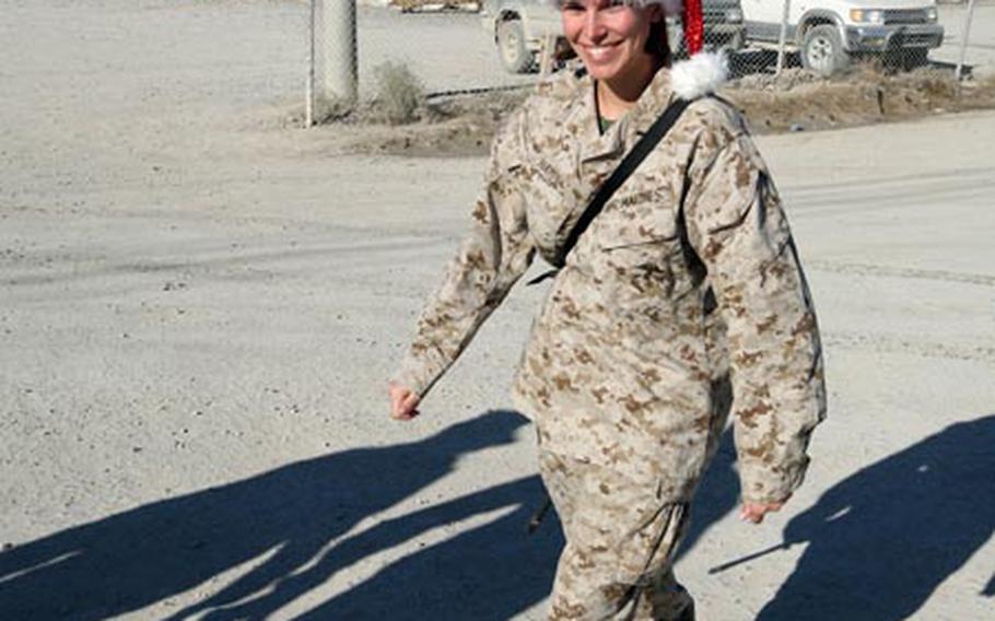 First Lt. Christina Hayes, 25, of Atlanta, Ga. with the Special Purpose Marine Air Ground Task Force-Afghanistan, displays the spirit of the season, topping off her desert fatigues with a Santa hat on Christmas Day at Kandahar Airfield, Afghanistan.
