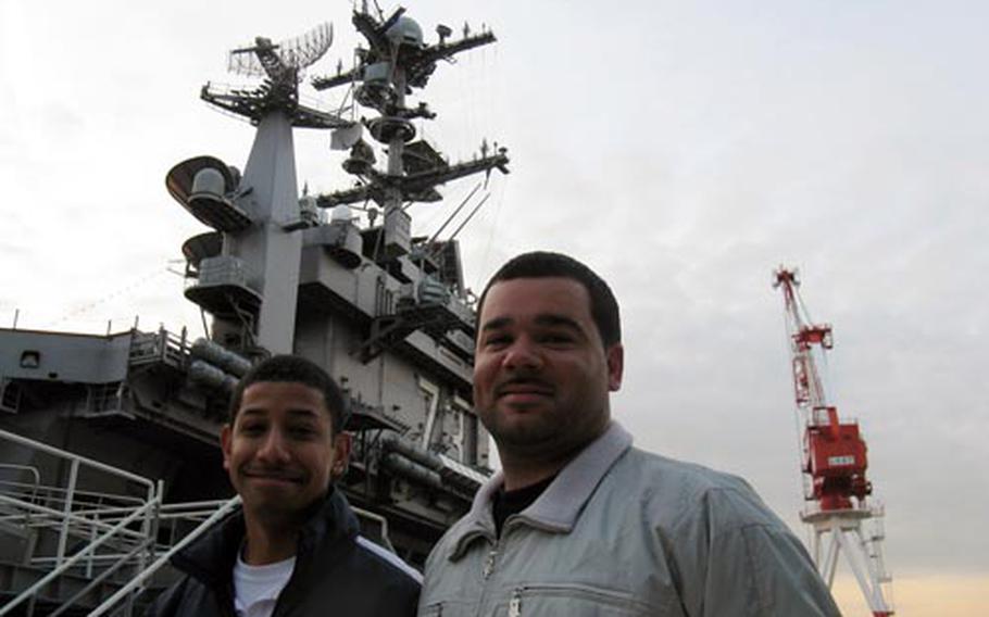 Petty Officers 1st Class Henry Caballero, left, and James Brice rescued of a Japanese man from the train tracks at Shinagawa Station in Tokyo on Friday. The two sailors jumped about five feet down to the track bed to save the unconscious man.