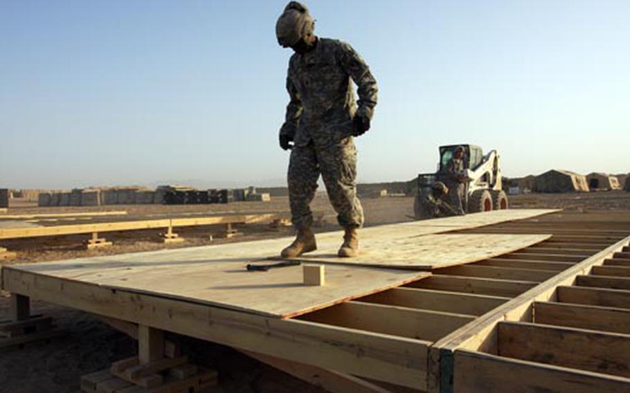 Sgt. Kenneth Kelly, of Detroit, maneuvers a sheet of plywood into place in September as he works on the flooring for a tent at Forward Operating Base Ramrod in Maiwand district, in Afghanistan’s Kandahar province. Kelly and other soldiers from Bravo Company, 62nd Engineers are building the base, which is the new center of operations for 2nd Battalion, 2nd Infantry Regiment. The battalion moved into the district to reinforce Canadian troops in Kandahar province, the heartland of the Taliban insurgency.