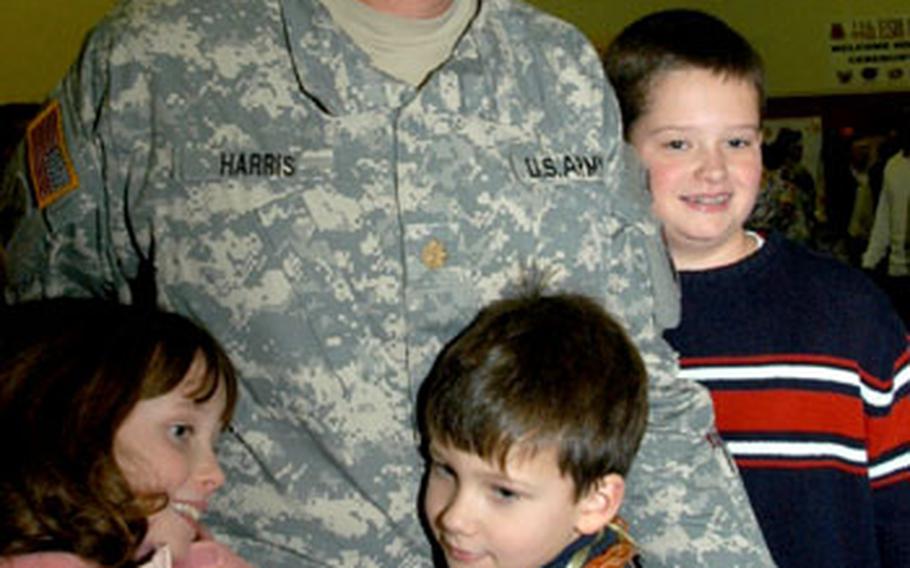 Maj. John Harris&#39; kids crowd around him, with 7-year-old Jack and 11-year-old Catherine hanging on to his legs.