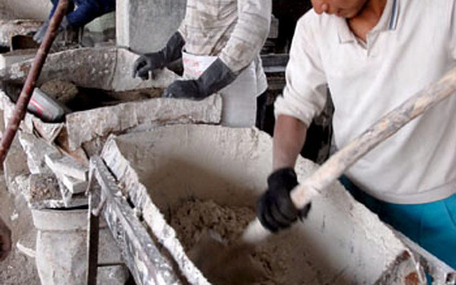 Workers make mix for tiles on Monday at a family-run factory in the Warij industrial district south of Baghdad.