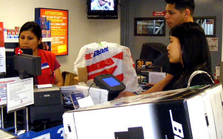 Jaime Flores and his wife, Jenna, return a stereo system, paper shredder and other items Friday at the Kadena Air Base Exchange. It was a surprisingly light day for gift returns, an AAFES store supervisor said.