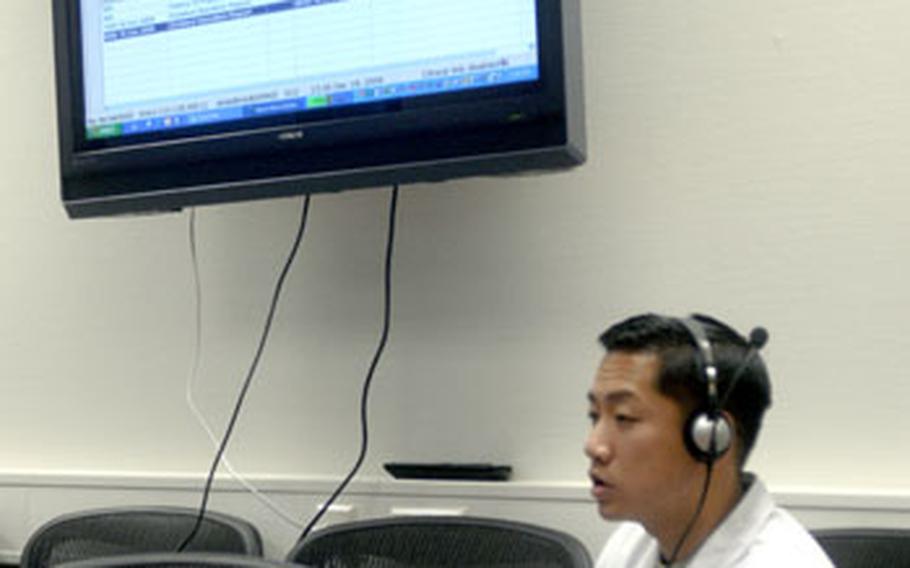 Maj. (Dr.) Hamilton Le, a surgeon at Landstuhl Regional Medical Center in Germany, demonstrates voice-recognition software new to the hospital. It allows doctors to have their notes typed out as they speak. Le talks into the headset microphone and his words appear on the computer.