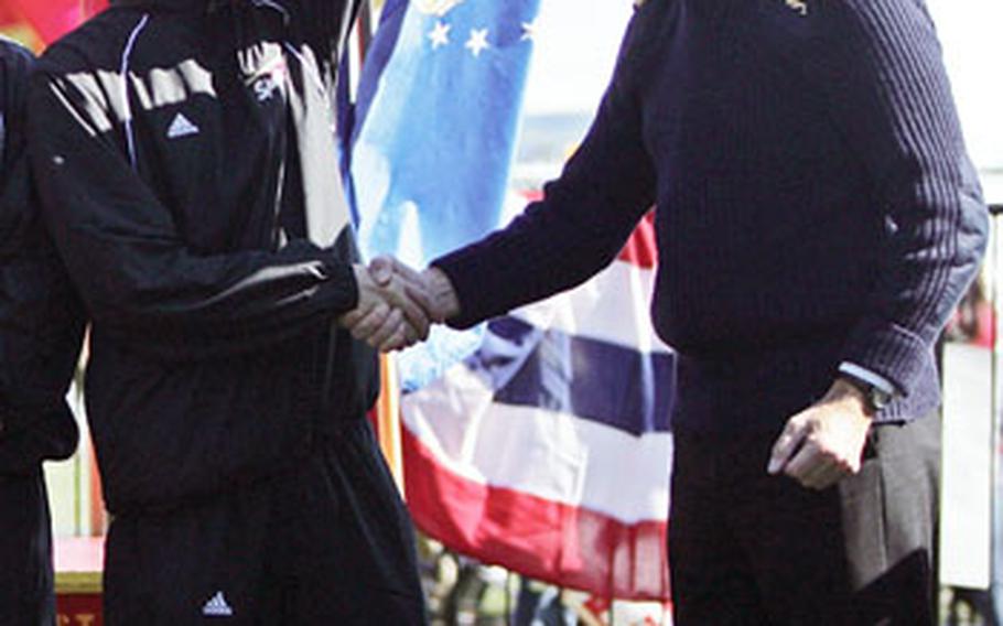 Kunish, left, celebrates the All-Marine running team’s win during an awards ceremony after retaining the Challenge Cup for defeating the British Royal Navy/Marine team at the 33rd Marine Corps Marathon Oct. 26 in Arlington, Va. The Challenge Cup winners are decided by adding the finishing times of the top three runners for each division.