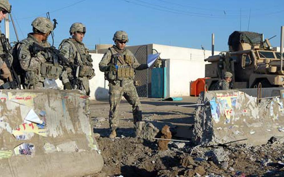 Soldiers inspect a crater left by an explosively formed projectile — a particularly lethal form of roadside bomb — that killed an American soldier Sunday in Baghdad’s Sadr City.