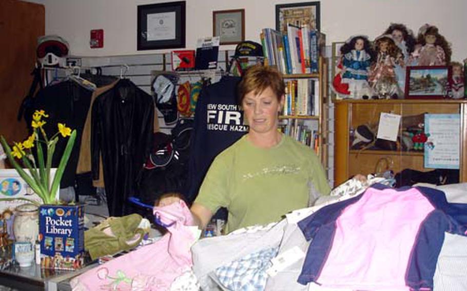 Holly Yager, a volunteer at Forgotten Treasures thrift shop, sorts through donations that will either be sold at the store or sent to charities in Naples and Iraq.