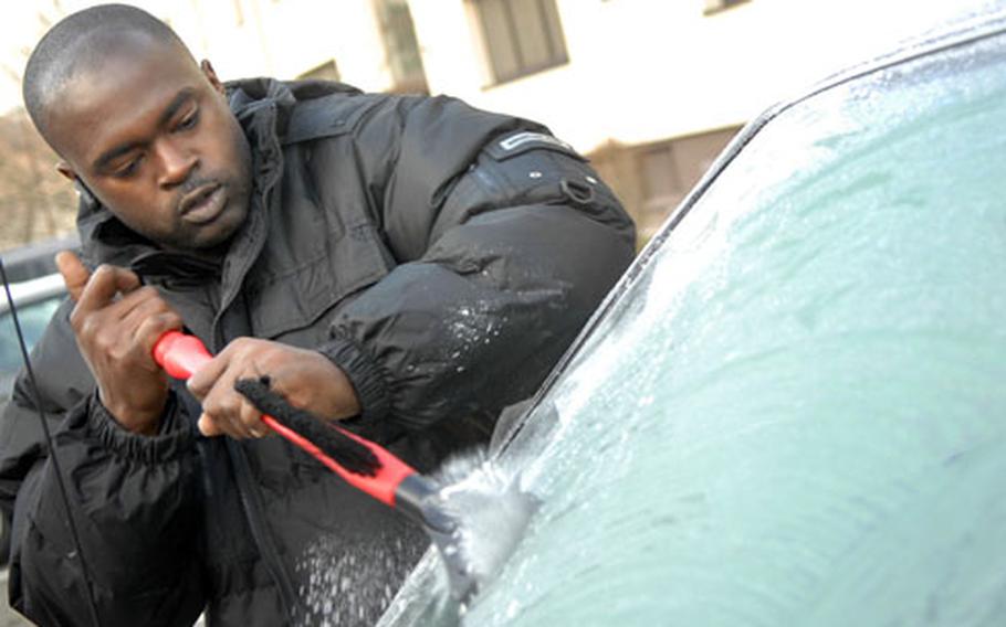 Staff Sgt. Keith Bartley, assigned to the 86th Maintenance Operation Squadron, scrapes the frozen dew off his windshield Tuesday on another sub-freezing morning at Ramstein, Germany.