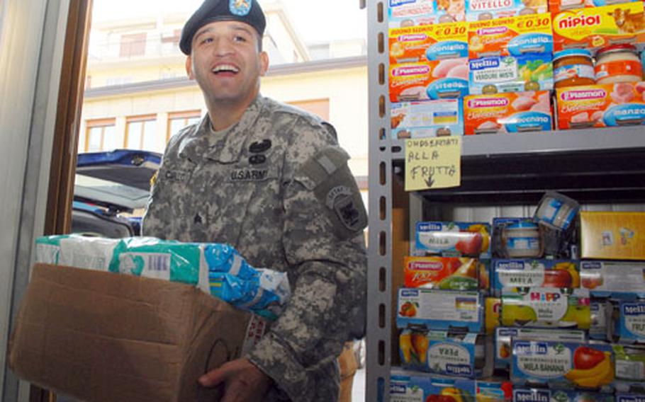 Sgt. Sergio Carillo, 27, of Los Angeles, a Southern European Task Force chaplain assistant, carries donated items into a Vicenza, Italy, food pantry run by the local Catholic archdiocese. Soldiers and families in the Vicenza military community collected food, baby formula and other items for a local charity in Vicenza.