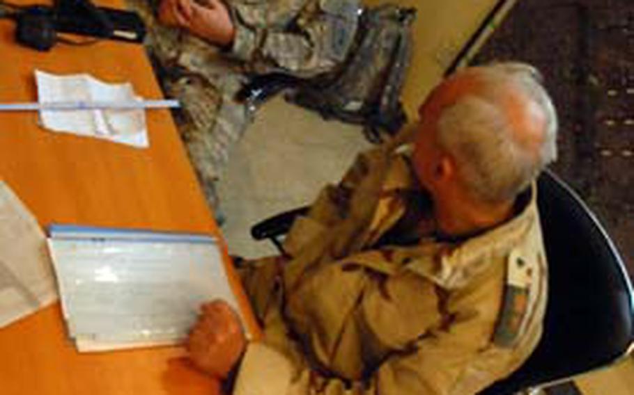 Maj. David Acker, an operations adviser, talks with Lt. Col. Aziz about the replacement of an Iraqi battalion commander at the 44th Iraqi Army Brigade headquarters in Baghdad’s Sadr City district.