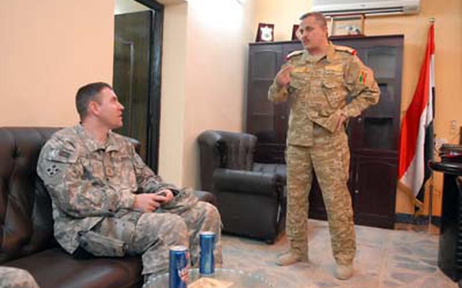Maj. David Acker, an operations adviser, talks with Col. Faris, the 44th Iraqi Army Brigade commander, Dec. 20 about problems with an American convoy that was emplacing concrete barriers at the brigade headquarters.