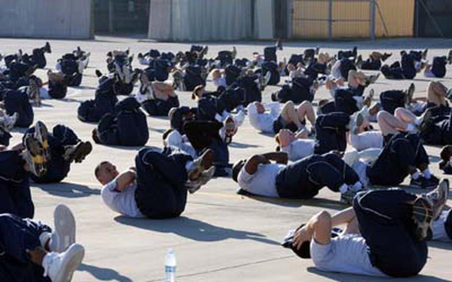Members of the 31st Aircraft Maintenance Squadron do sit-ups as part of Air Force Wingmen Day at Aviano Air Base, Italy.