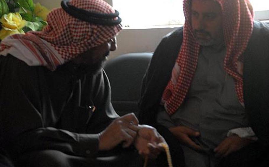 Members of a local government council talk privately during a meeting in Mushada, Iraq, on Wednesday. One of the councilmen was killed the previous week by a “sticky bomb” planted on his vehicle. While the assassination of government officials remains rare, violence in the region around Mushada has turned to targeted killings, according to the Army battalion in charge here.