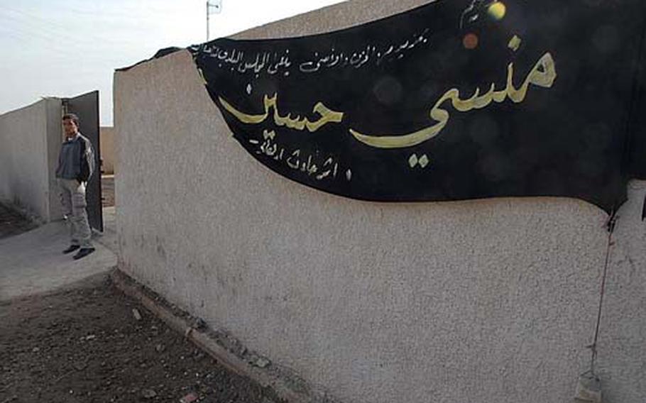 A martyr banner hangs along the wall outside the government center in Mushada, Iraq.