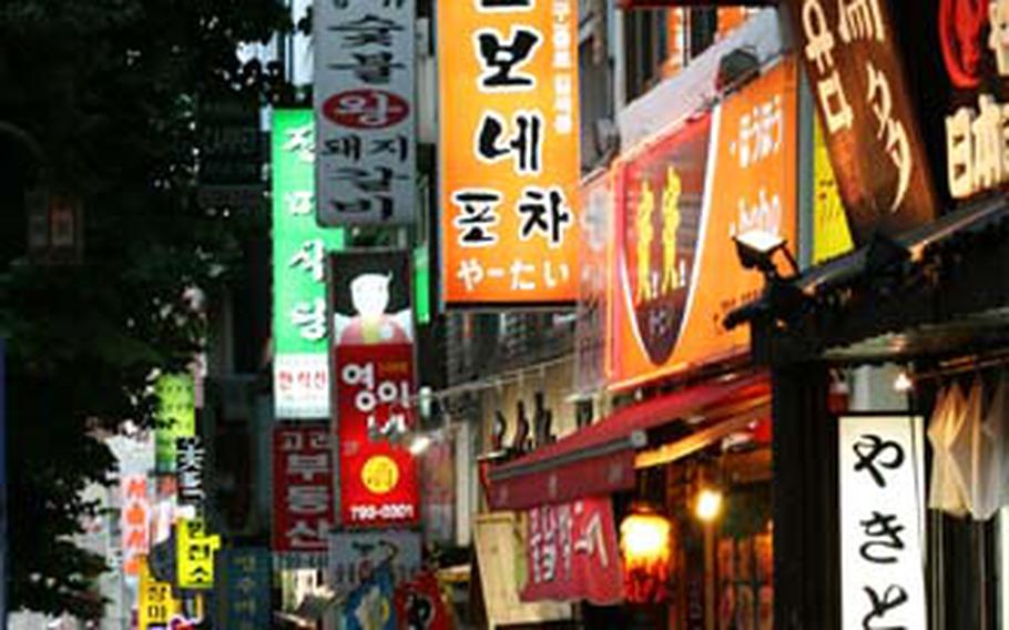 Pedestrians walk down a street in the Itaewon entertainment and shopping district.